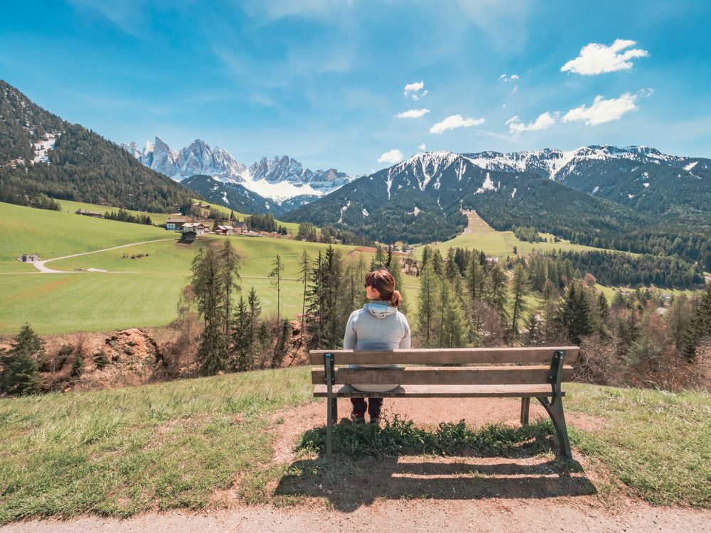 woman admiring the views of Small beautiful village between mountains with snow