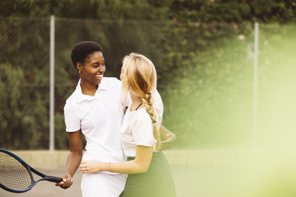 Portrait of two happy women in a tennis court