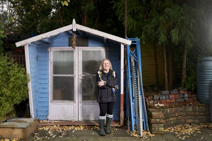 Full length shot of woman standing with arms crossed outside blue hut