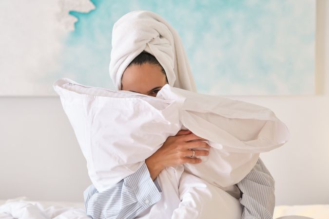 Woman hugging pillows in bedroom