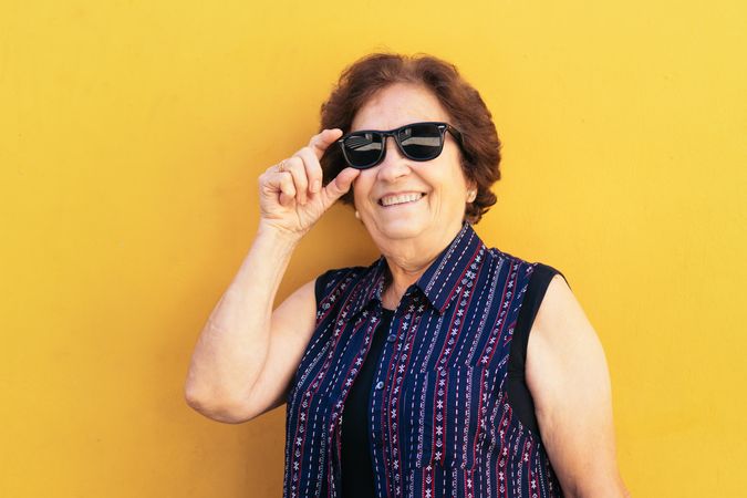 Stylish mature woman in sunglasses and colorful clothes