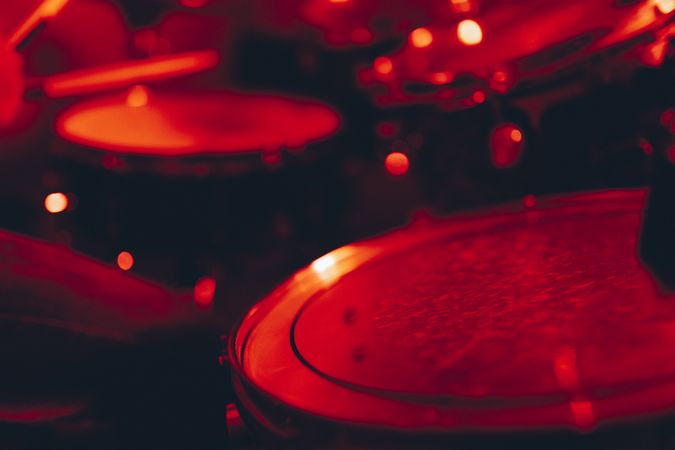 Man with drumsticks playing on drums in redness