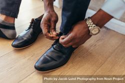 Man putting on and tying formal shoes 0KekZ4