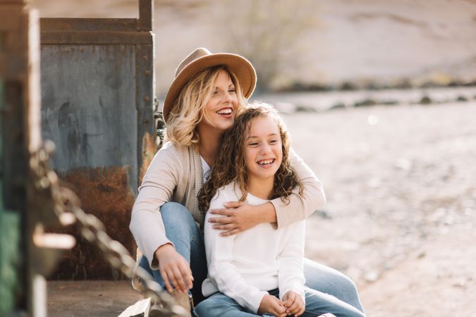 Mother hugging girl in truck body