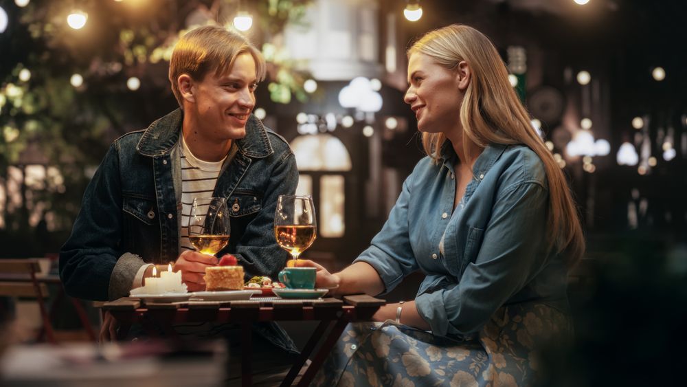Young Man and Woman Meeting at a Restaurant, Having a Carefree Evening Date on a Terrace.