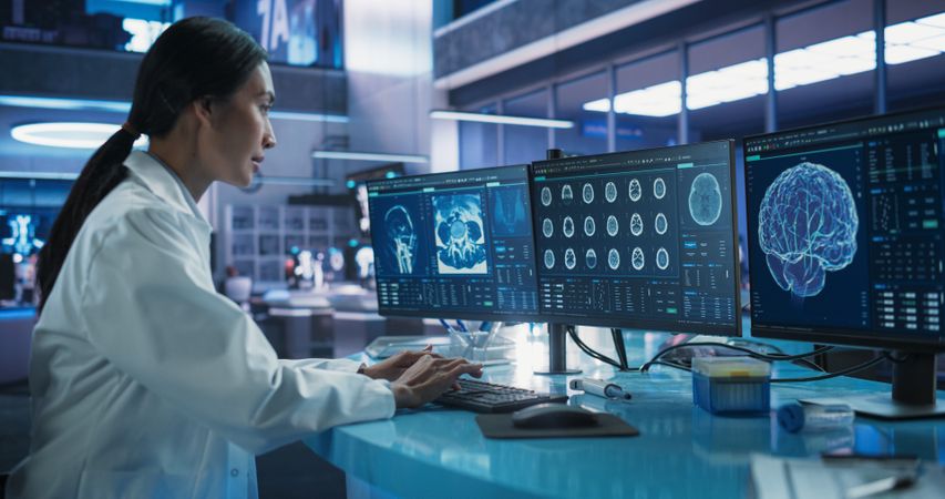 Hospital Research Laboratory: Asian Female Medical Scientist Using Computer with Brain Scan MRI Images.