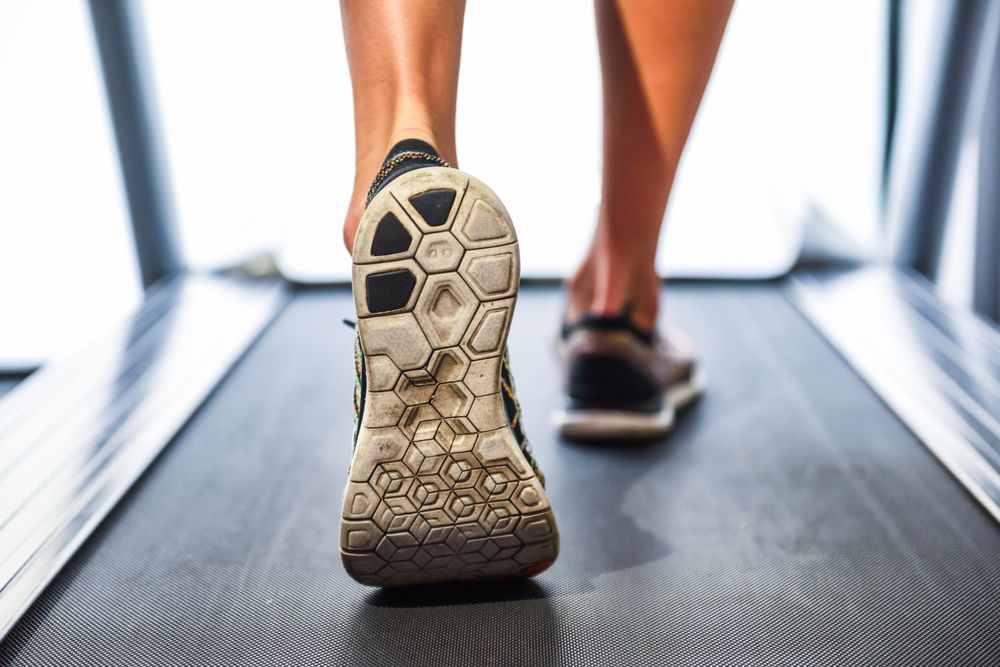 Feet of man on running machine