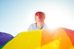 Young woman with red hair holding rainbow flag