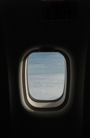 Sky and clouds behind plane window