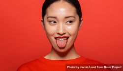 Korean female model making funny face against red background 4mRaBb