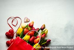 Tulips in shopping bag with red ribbons on grey counter 5XrrKK