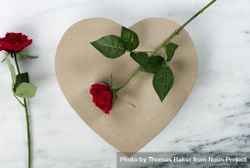 Happy Valentine’s Day with a large heart shape giftbox and red roses on marble stone 4BZkE4
