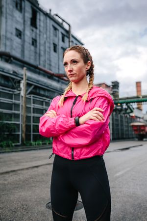 Sportswoman with boxer braids posing in front of a factory