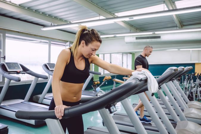 Woman cooling down after intense training on treadmill in gym