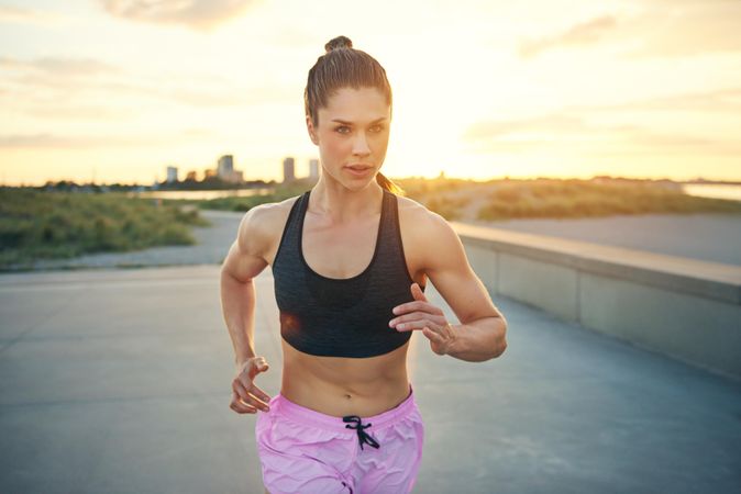 Fit woman jogging outside in sports bra