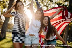 Smiling women at park with USA flag on a sunny day 4AOez0