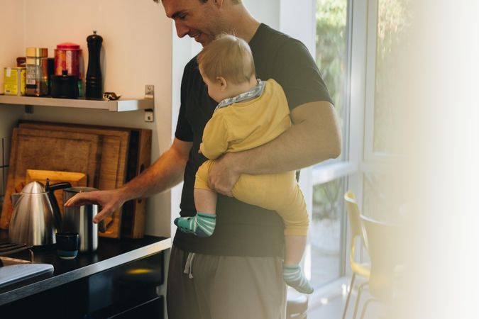 Man on paternity leave with baby in kitchen