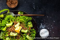 Green fresh salad on concrete background served with flax seed and salt with copy space 0yX6kn