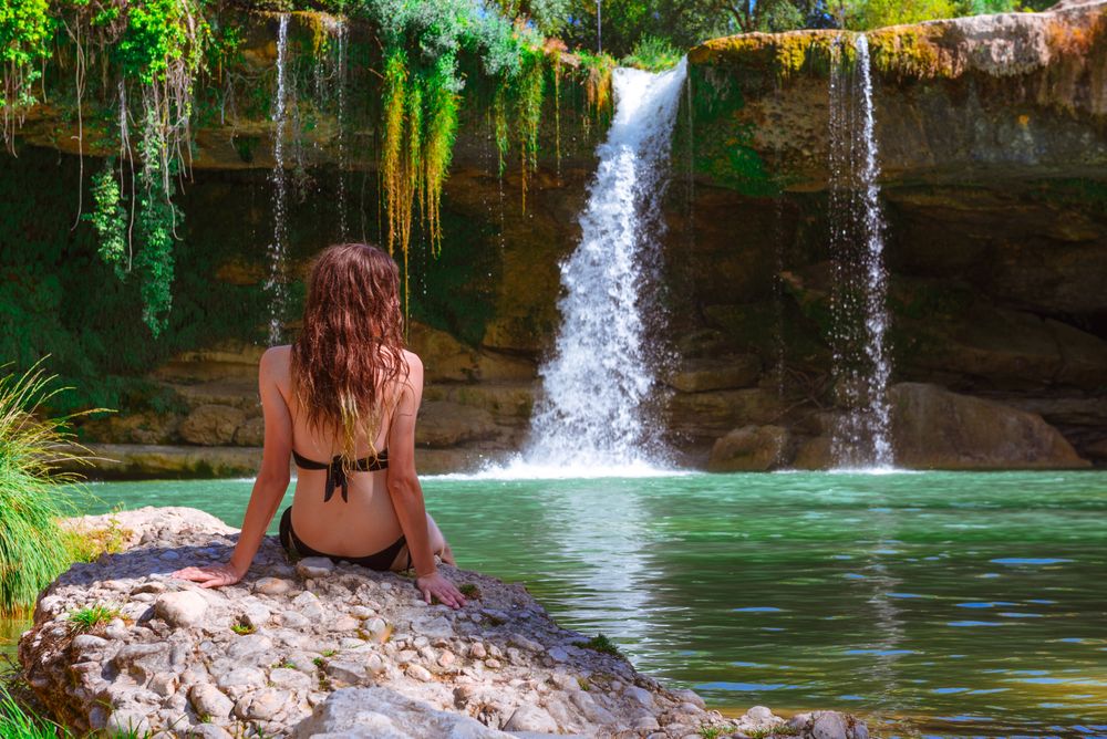 Young female relaxing near waterfall