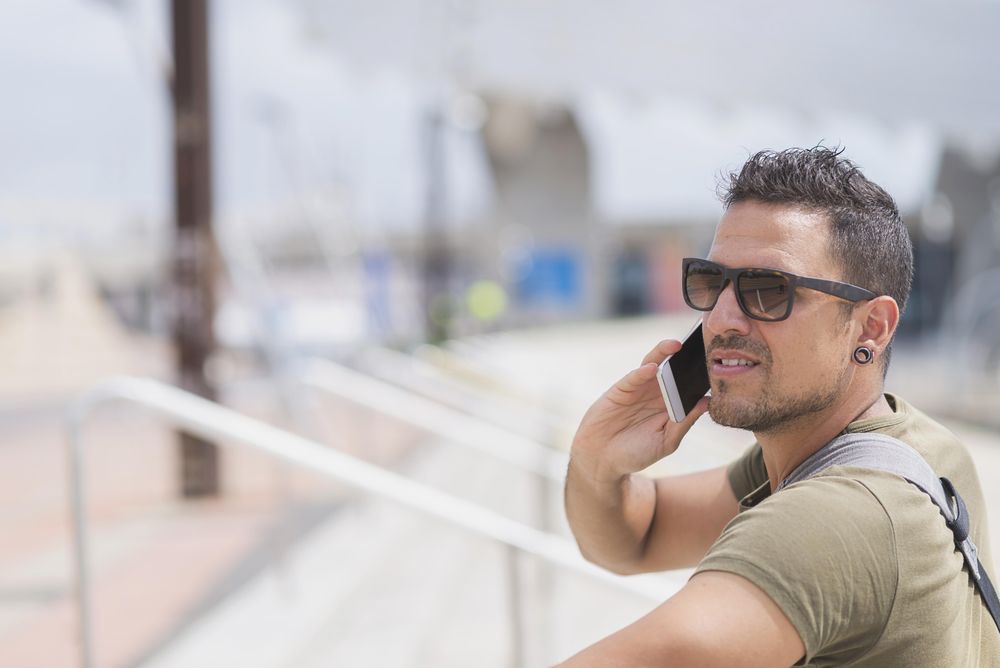 Male looking to his side while talking on cellphone