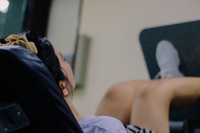 woman using leg press machine in gym