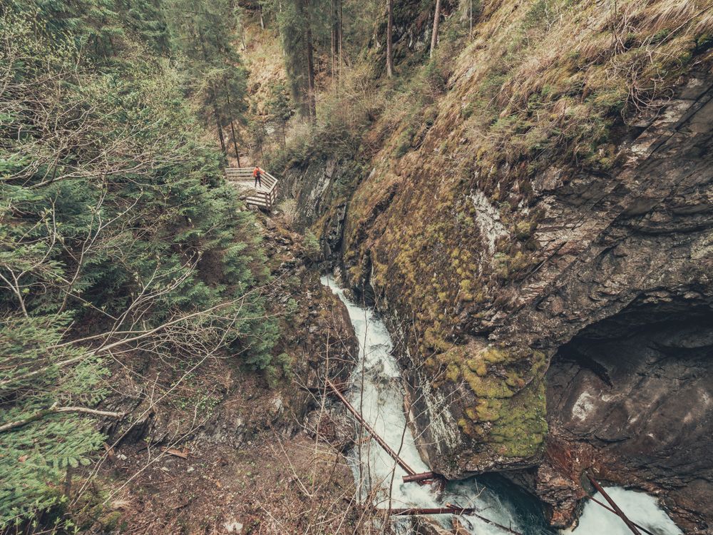 Traveller admiring picturesque view of mountain stream