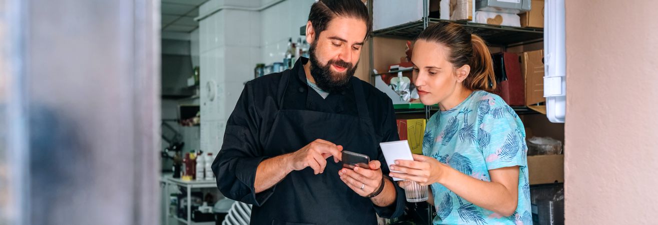 Cook showing mobile to waitress during break