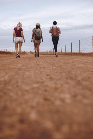Female friends walking on a rural road after their car breakdown