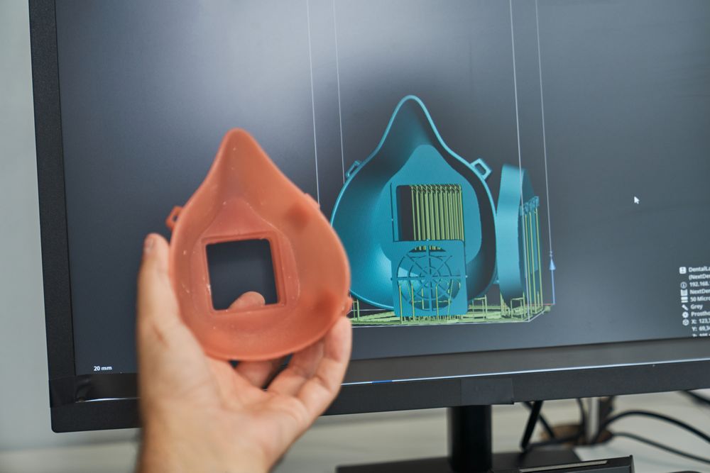 Crop person comparing 3d figure of respirator and 3d model on sc