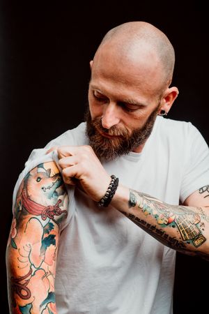 Young bald guy showing tattoos