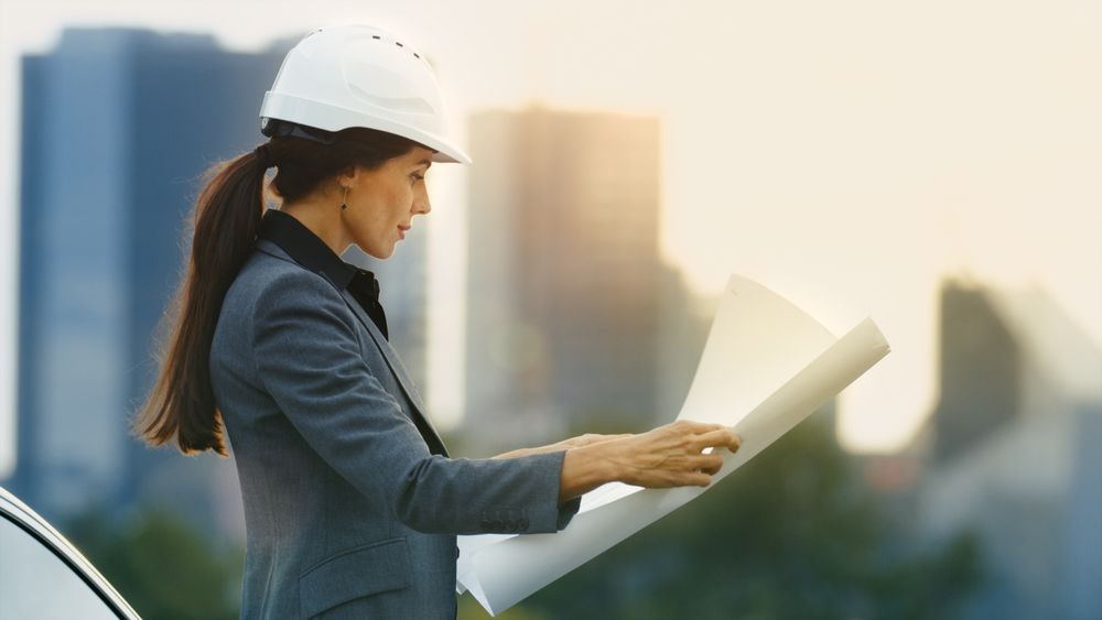 Female Real Estate Developer Looks at the Project Drafts while Standing.