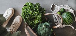 Overhead shot of grocery shopping jute full of fresh produce, with shoes, mesh bag