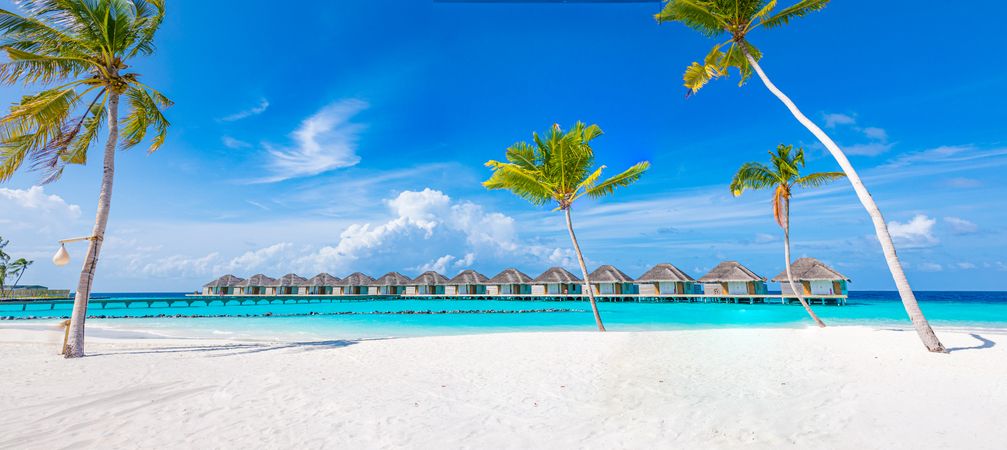 A row of overwater bungalows in the Indian Ocean, wide