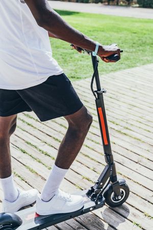 Black man riding on electric scooter in park