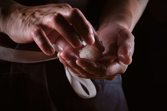 Male shushi man hands preparing different pieces of makis