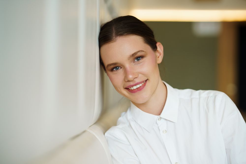 smiling woman in elegant white clothes in a cafeteria