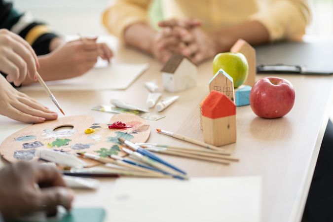 Background of class room of paint and brushes on the table with apple