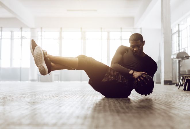 Athletic man doing abdomen exercise on the floor