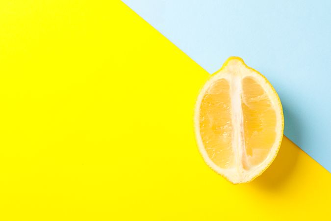 Fresh lemon on two tone background, space for text