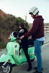 Man helping woman sit to bike