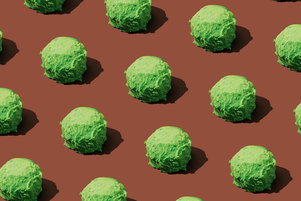 Green ice cream scoops in rows on brown background