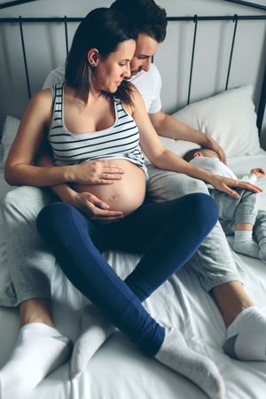 Pregnant woman with her husband looking son