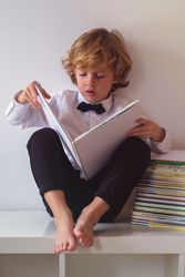 Boy in suit reading books