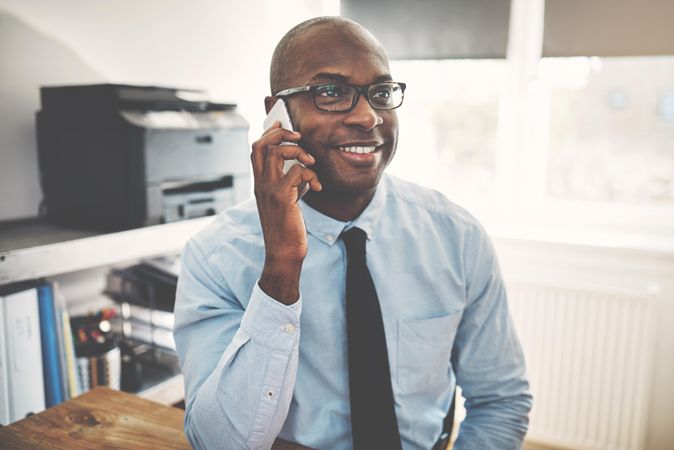 Man smiling on phone in home office