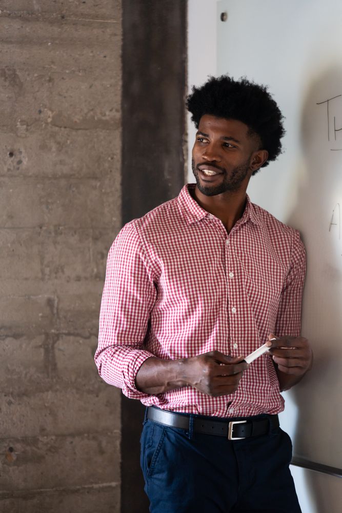 Man holding marker standing at a dry erase board