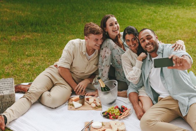 Young couples having fun taking a selfie while having a picnic