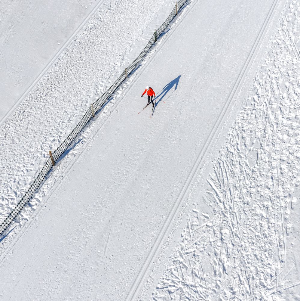 Skier running on the track. Snow field. Aerial.