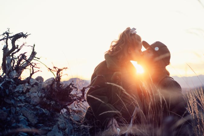 Man and woman kissing outdoor during golden hours