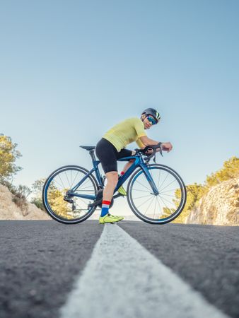 man resting while riding a bicycle on a mountain road