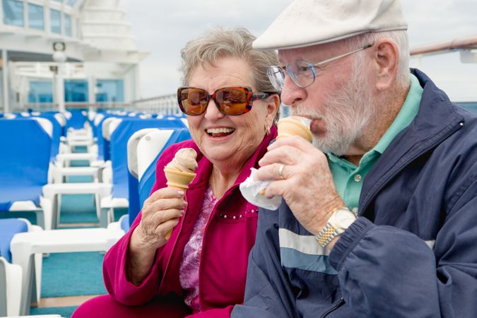 Happy Mature Adult Couple Enjoying Ice Cream On The Deck of a Luxury Passenger Cruise Ship.